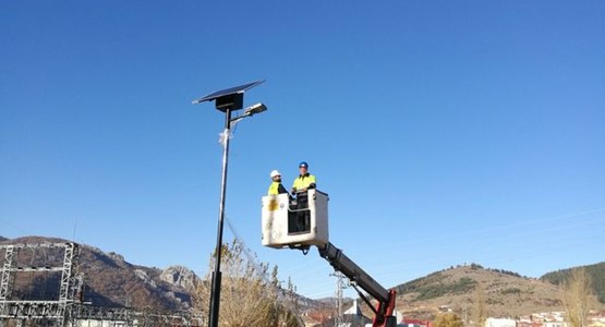 hombres instalando panel solar en un poste